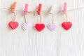 ValentineÃ¢â¬â¢s Day. Sewed pillow hearts row border on red, pink and white clothespins at rustic white wood planks Royalty Free Stock Photo